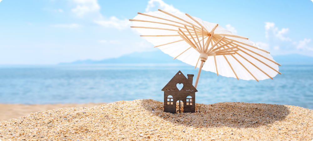 игрушечный фасад дома на пляже с зонтиком